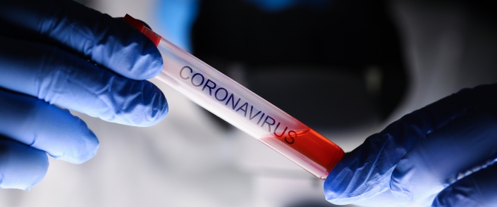 Male chemist hand in blue protective gloves hold Coronavirus News Bild